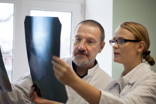 Alte und junge Ärzte untersuchen Röntgenbilder - Foto, Bild