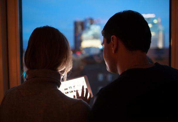 Пара с помощью планшетного ПК в вечернее время
 - Фото, изображение