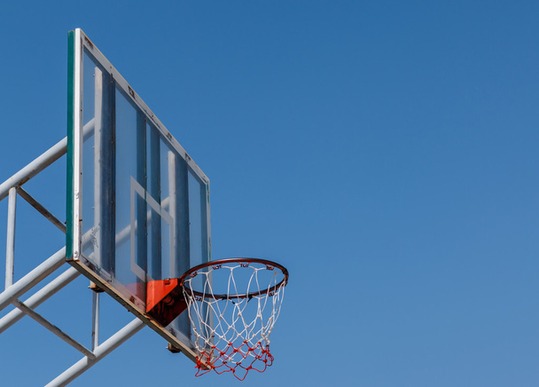 Basketbol yönetim kurulu ve mavi gökyüzü ile çember. - Fotoğraf, Görsel