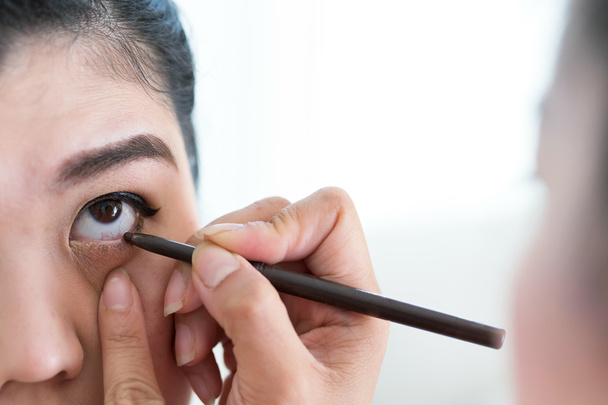 Make-up Schönheit mit Pinsel Eyeliner auf hübsche Frau - Foto, Bild