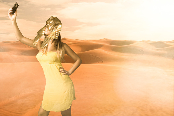 Woman in Egyptian sphinx mask take selfie - 写真・画像