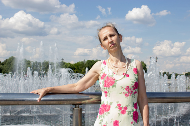 Femme debout près de la fontaine
 - Photo, image
