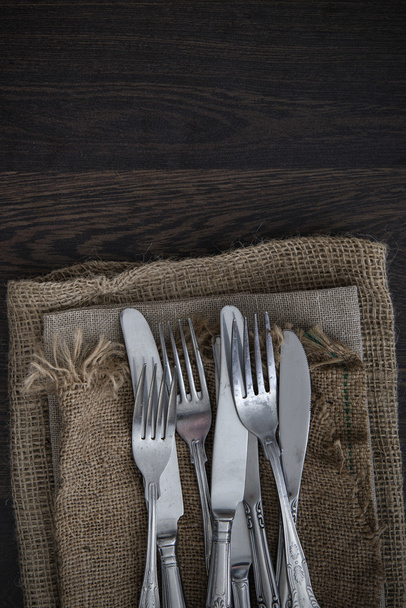Vintage cutlery on hessian cloths on rustic wooden background - Photo, Image