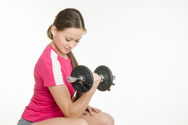 She shakes dumbbell arm muscles - Photo, image