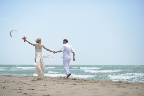 Giocoso matrimonio coppia sulla spiaggia
 - Foto, immagini