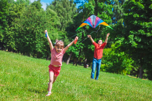 The girl and her father play with a kite. - 写真・画像