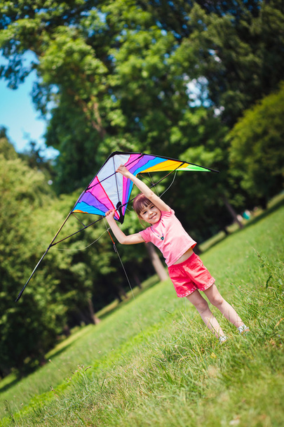 Menina jogar com pipa colorida no parque
.  - Foto, Imagem