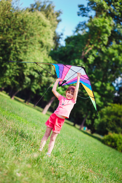 Little girl play with colored kite in the park.  - Foto, imagen
