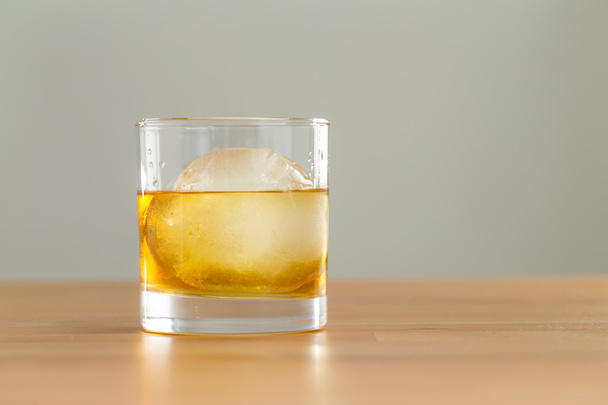 Whiskey drink on table with ice cube - Фото, изображение
