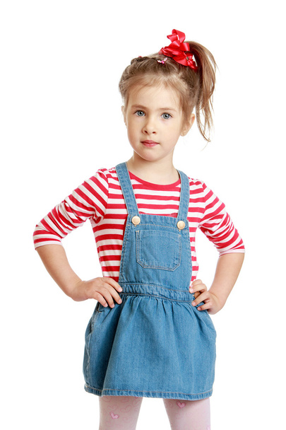 Little Caucasian blond girl in a short denim dress  - Foto, imagen