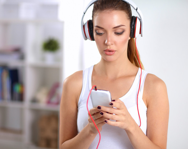 Woman with headphone listening music standing at home - Фото, изображение