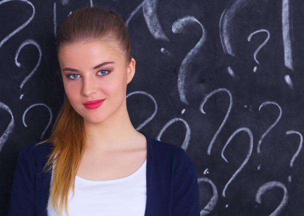 junges Mädchen mit Fragezeichen auf grauem Hintergrund - Foto, Bild