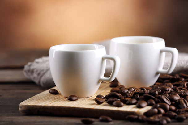 Kopjes koffie en bonen op onscherpe achtergrond - Foto, afbeelding
