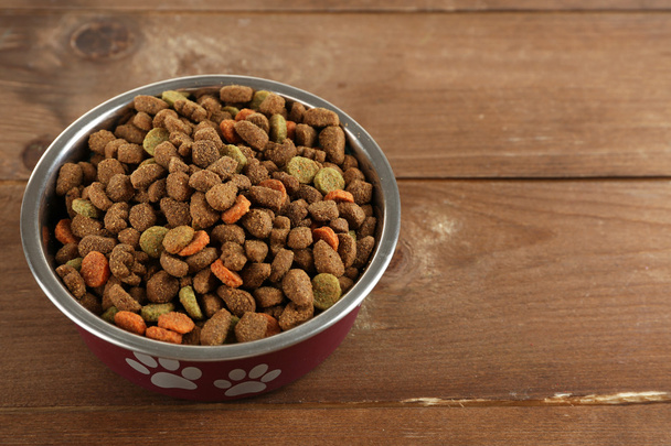 Dog food in bowl on wooden table - Fotó, kép