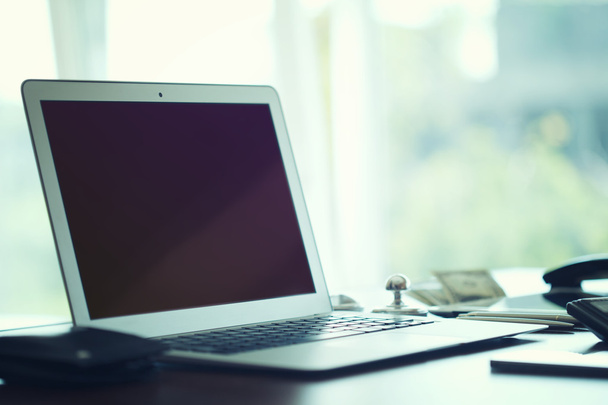 Geschäftstechnologien. Arbeitsplatz mit offenem Laptop auf modernem Holztisch. - Foto, Bild