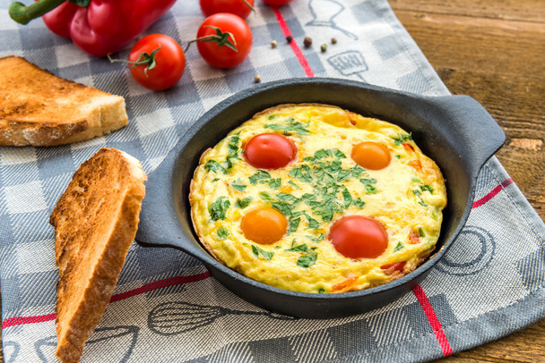 Frittata (Italiaanse omelet) met paprika en cherriy tomaten. - Foto, afbeelding