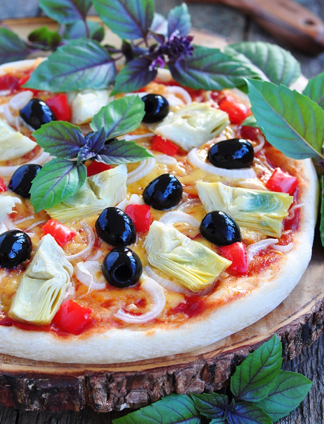 Gezonde pizza met artisjokken, olijven, uien, paprika, basilicum en olijfolie - Foto, afbeelding