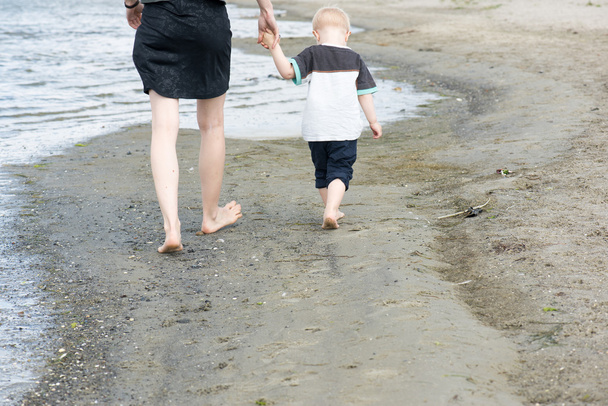 Madre e bambino a piedi lungo la spiaggia
 - Foto, immagini