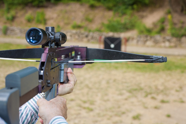 Man targeting with a scoped crossbow - 写真・画像