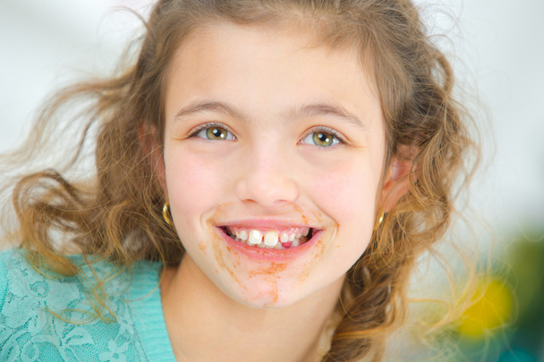 Meisje met chocolade rond haar mond - Foto, afbeelding