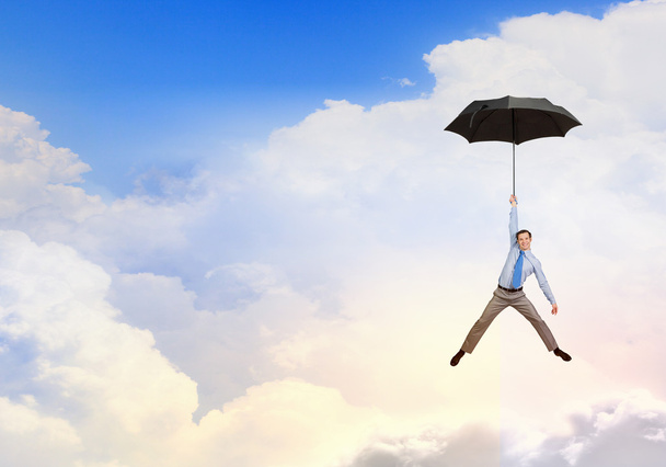 Mann fliegt auf Regenschirm - Foto, Bild