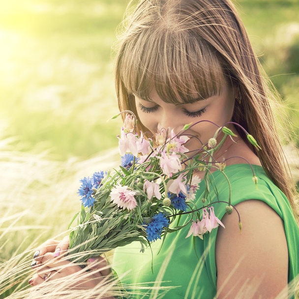 Smyslná dívka vonící kytice lučních květin - Fotografie, Obrázek