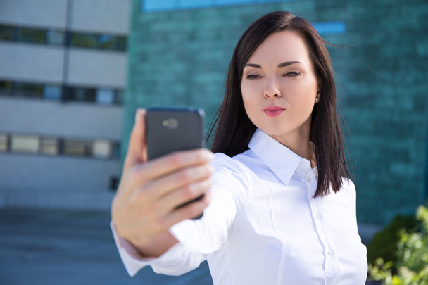 business woman with "duck face" making selfie photo on smartphon - Photo, Image