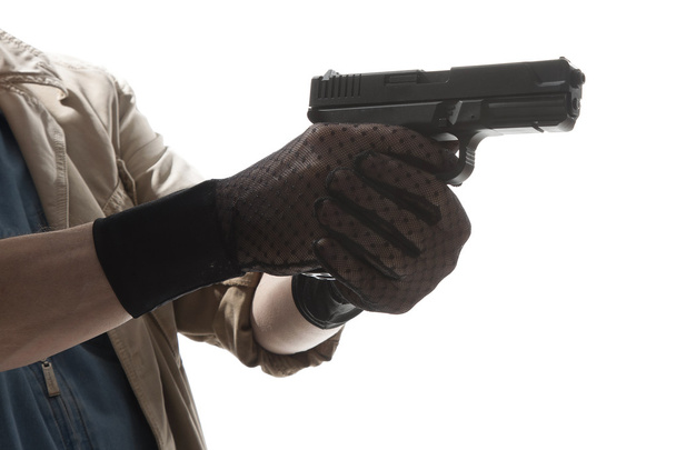 Close up van mannelijke handen in handschoenen met pistool - Foto, afbeelding