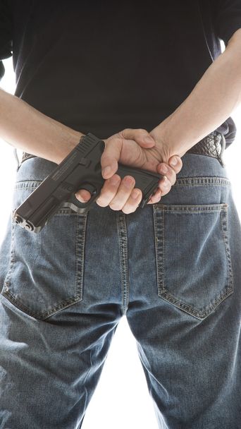 Hombre escondiendo arma detrás de su espalda
 - Foto, Imagen
