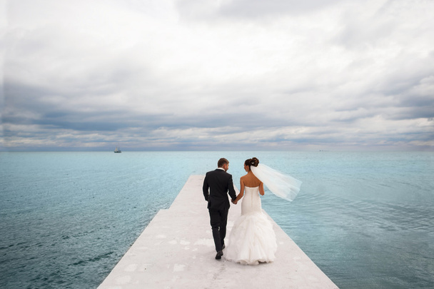 Jeunes mariés sur le quai de la mer
. - Photo, image