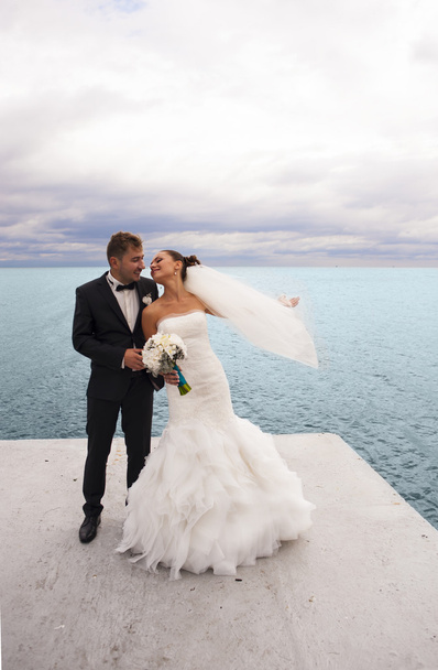 The groom and bride are having fun by the sea line. - Photo, Image