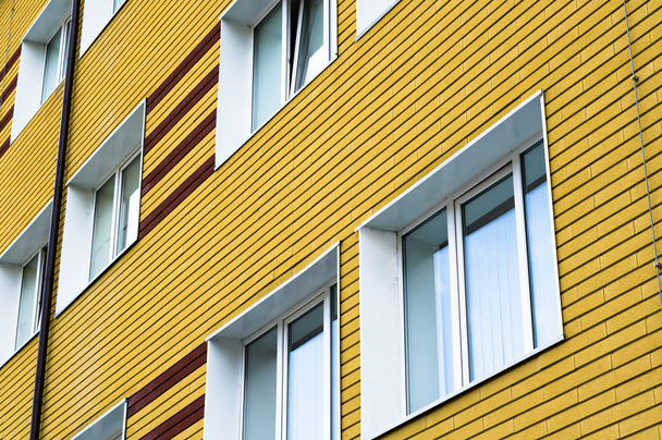 Beaucoup de fenêtres dans le bâtiment en brique jaune
 - Photo, image