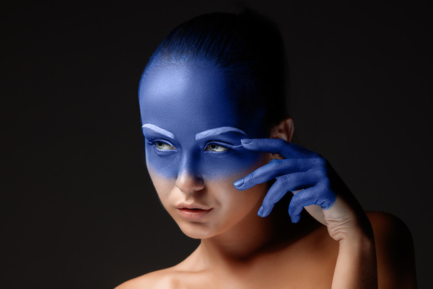Portrait of a woman who is posing covered with blue paint - Φωτογραφία, εικόνα
