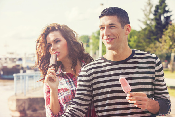 Young couple eating ice cream on a sunny day - Fotoğraf, Görsel