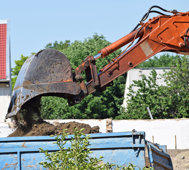 L'escavatore sta caricando un camion alla costruzione della strada
 - Foto, immagini