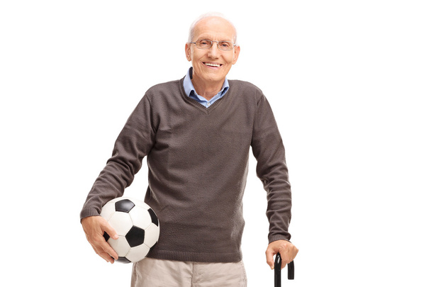Senior gentleman with a cane holding a football - Фото, изображение