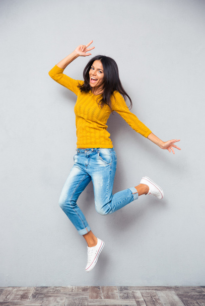 Full length portrait of a funny woman jumping  - Фото, изображение