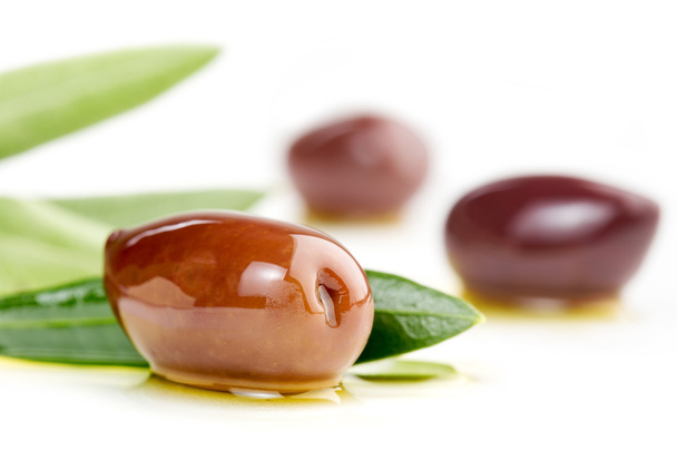 Close up of kalamata olives and olive leaves isolated on white - Valokuva, kuva