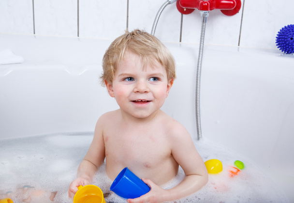 Adorable toddler boy having fun in bathtub - 写真・画像