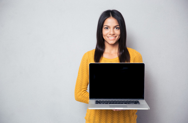 Happy woman showing blank laptop screen  - Foto, afbeelding