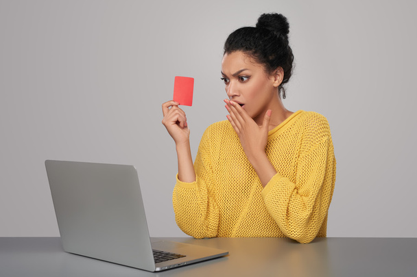 Shocked woman with laptop holding credit card - Photo, image
