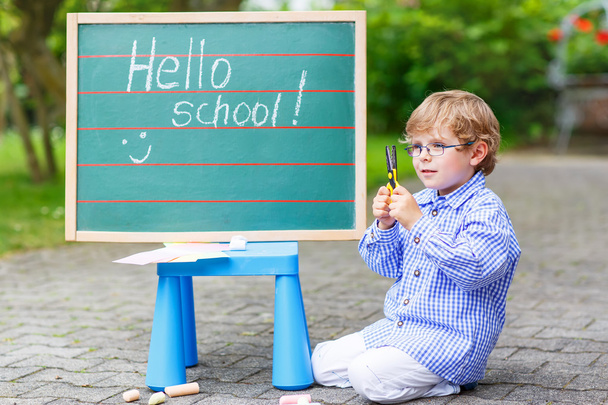 Schattige kleine jongen-jongen met glazen op blackboard beoefenen van writin - Foto, afbeelding
