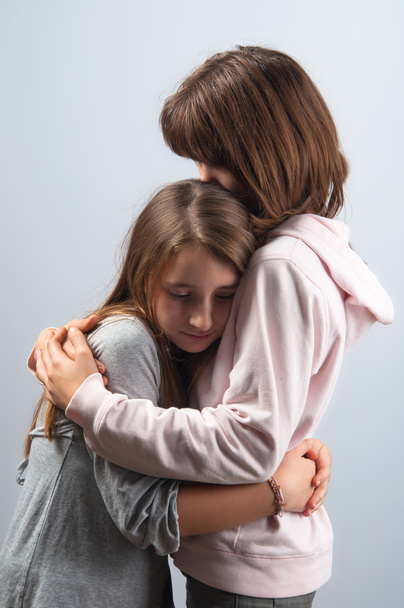 Teenagermädchen umarmen sich in gegenseitiger Unterstützung - Foto, Bild