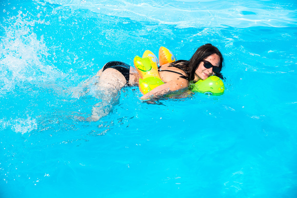 Girl swims in the pool on an inflatable circle - Фото, зображення
