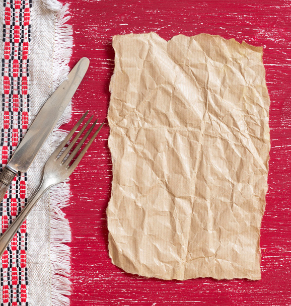 Fourchette et couteau vintage sur serviette en bois rouge et papier artisanal
 - Photo, image