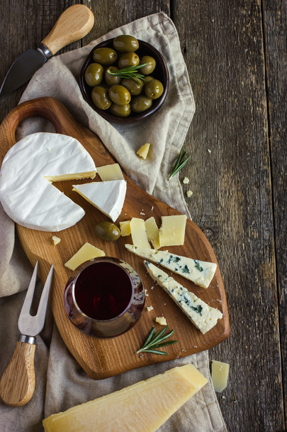 Assortment of various types of cheese on wooden board - Photo, image