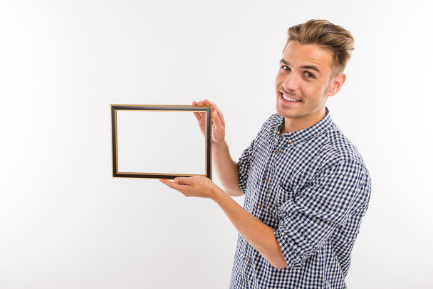 Handsome man holding a picture frame - Foto, Imagem
