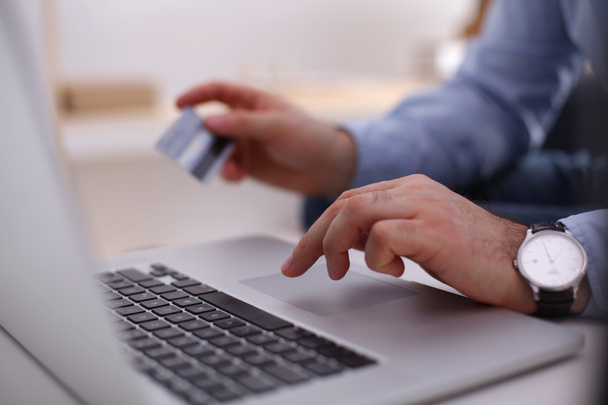 Бізнесмен використовує свою кредитну картку для онлайн транзакції
 - Фото, зображення