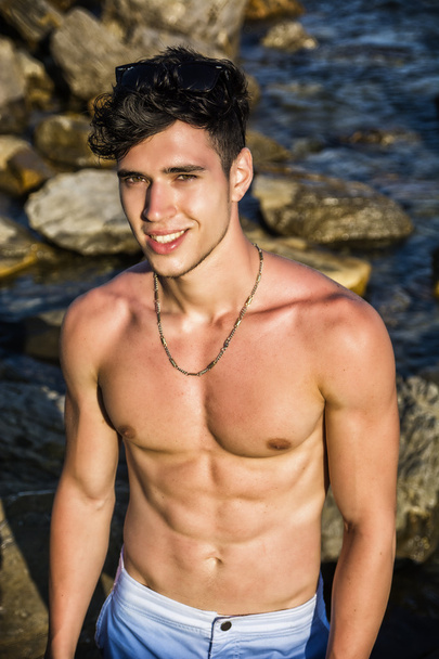 Muscular young man shirtless at sea - Photo, Image