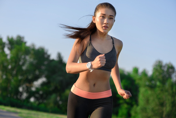 Young asian woman jogging at park - 写真・画像